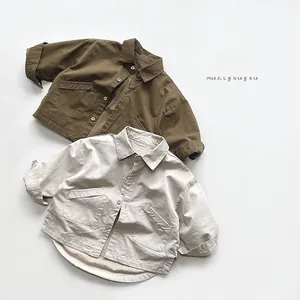 Detail of olive green and off-white kid's utility shirts showing pockets and fabric texture