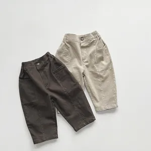 Detailed texture of cotton linen kids trousers in dark brown and beige with elastic waist