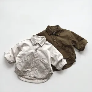 Detail view of linen texture, symmetric big pockets, and curved hem on kids cotton shirts