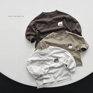 Detailed close-up of three cotton kids' long-sleeve T-shirts in olive, coffee, and beige