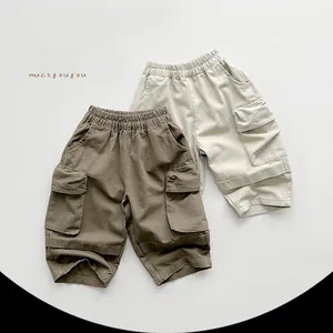 Flat lay detail of kids cargo shorts in brown and beige colors with large pockets