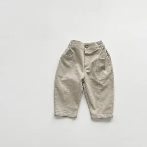Detailed view of kids khaki cotton trousers featuring elastic waist and button closure