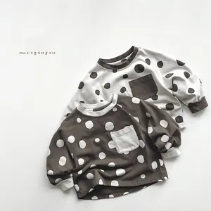 Close-up of kids polka dot long sleeve t-shirts with pocket detail and ribbed cuffs