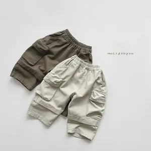 Flat lay of kids cargo shorts in olive and beige with elastic waist and flap pockets