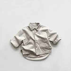 Detail view of beige kids shirt with oversized cargo pockets and asymmetric hem