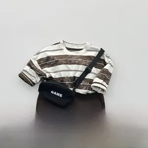 Flat lay of kids vintage striped long sleeve tee with coffee casual shorts and bag