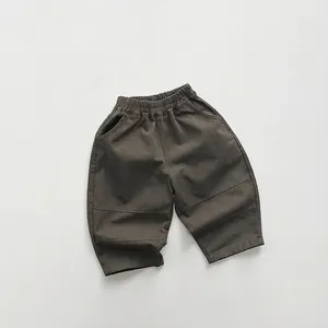 Dettaglio dei pantaloni in cotone verde oliva per bambini con elastico e tasche