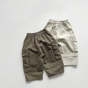 Flat lay of kids cotton cargo pants in dark brown and beige with elastic waist pockets