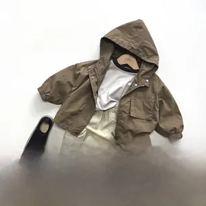 Flat lay of kids outdoor utility outfit with brown hooded jacket and khaki cargo shorts