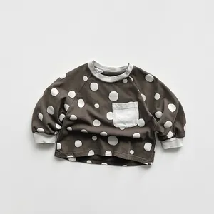 Close-up of kids polka dot sweatshirt with rib cuffs and contrast pocket detail