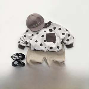 Flat lay of retro-style kids outfit with coffee polka dots hoodie and khaki pants
