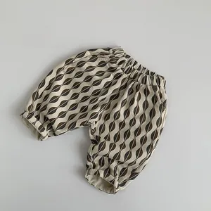 Vue détaillée du pantalon bouffant en coton pour enfant avec motifs de feuilles ondulées