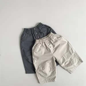Detailed flat lay of children's cotton loose pants with elastic waist and button accents