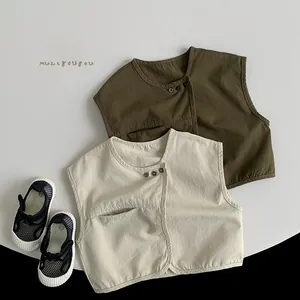 Détail de gilets pour bébé en coton et lin avec des sandales d'été en maille