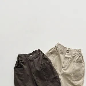 Close-up of cotton twill texture and elastic waist with wooden button on kids pants