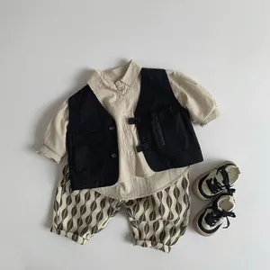 Three-piece retro kids outfit with khaki shirt, black utility vest, and patterned pants