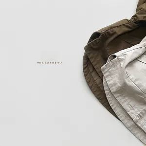 Detail view of cotton linen pants featuring olive green and beige fabric stitching