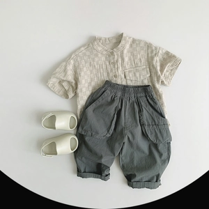 Flachbild-Detail von atmungsaktivem Baumwollleinen-Kinderhemd und grauer Hose