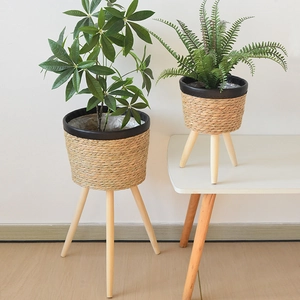 Detail of hand-woven rattan planters with waterproof lining and tripod wooden legs