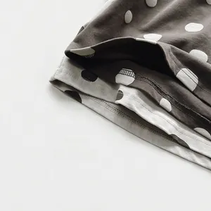 Close-up of high-quality overlock stitching on polka dot knit fabric for kids