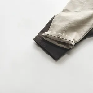 Detail of neatly rolled cuffs on thick cotton twill casual trousers for children