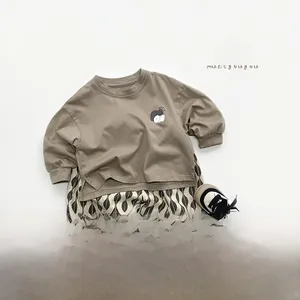 Detailed flat lay of toddler autumn outfit with camel t-shirt and wave pattern trousers
