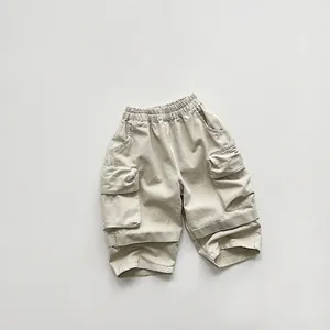 Detail of children's beige cargo shorts with elastic waist and large flap pockets