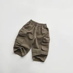 Close-up of olive green cargo shorts for kids with elastic waist and large side pockets
