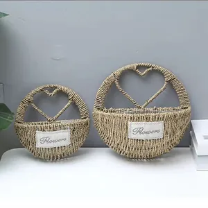 Detail of two handmade woven straw baskets with heart design and Flowers label