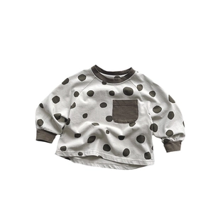 Kids long sleeve cream sweatshirt with dark brown polka dots and front pocket detail