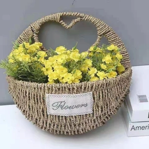 Detail of woven straw flower basket with heart handle and a decorative Flowers label