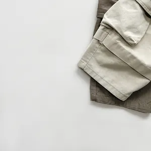 Detail view of beige and brown cargo pants with utility pockets and reinforced stitching