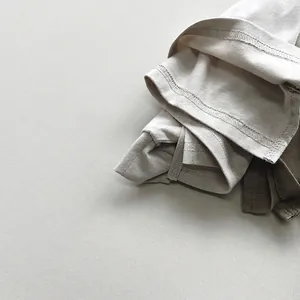Minimalist cotton knit T-shirts for kids in beige and dark brown with rolled hem details