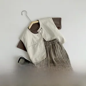 Flat lay of kids' three-piece clothing set with brown T-shirt, vest, and striped pants