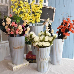 Close-up of vintage galvanized iron flower bucket with vertical ribbing and jute handles