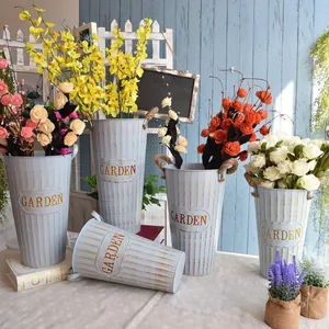 Detail of vintage blue metal flower bucket with Garden text and rustic jute handles