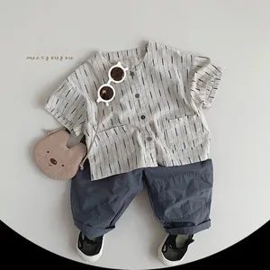 Flat lay of kids striped cotton shirt and dark grey casual pants with fashion accessories