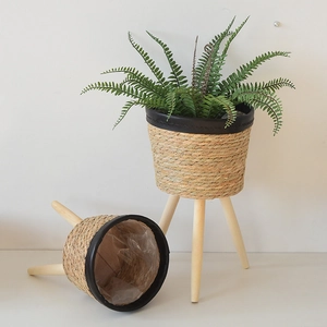 Detail of hand-woven straw planter with waterproof liner and three wooden legs