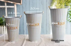 Detailed view of grey metal garden bucket trio with gold vertical stripes and Garden text