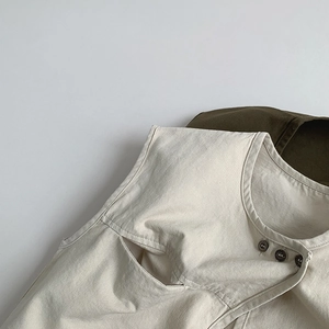 Détail du gilet en toile vintage avec boutons latéraux et poches fonctionnelles