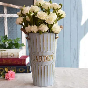Detail of vintage blue metal flower bucket with Garden text and white roses