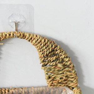Detail of hand-woven straw basket texture showing green and yellow weave on wall hook