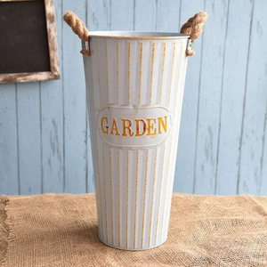 Detail of vintage white garden flower bucket with yellow stripes and hemp rope handles