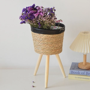 Nordic hand-woven seagrass planter with wooden legs and elegant black leather trim details
