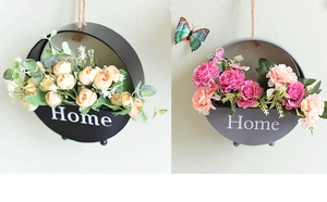 Detail of round metal wall hanging flower baskets with Home text in black and gray