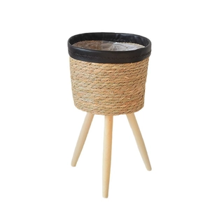 Nordic woven rattan plant stand with wooden tripod legs for indoor greenery decor
