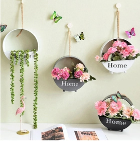 Modern wall-mounted round flower pots in black, white, and grey with faux greenery decoration