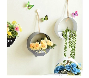 Detail of round wall-mounted iron flower pots with Home lettering and rustic ropes