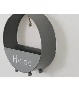 Close-up of matte grey iron wall-mounted storage basket with white Home lettering