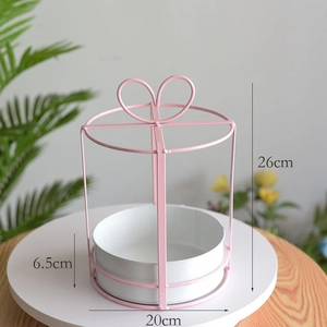 Pink heart-shaped metal flower basket rack with white base measuring 26cm in height